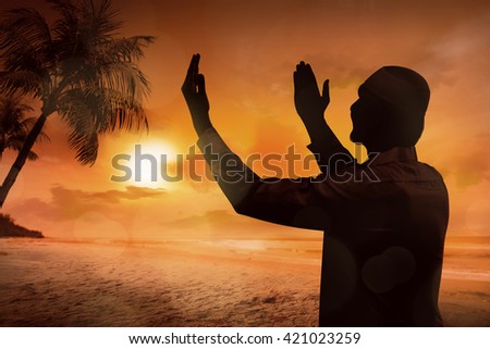 Silhouette of young muslim man praying on the beach