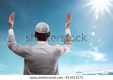 Back view of young muslim man praying