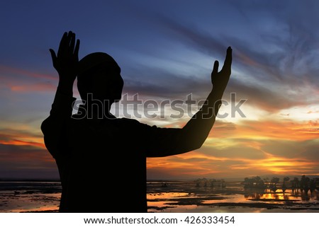 Image of silhouette man praying with sunset background