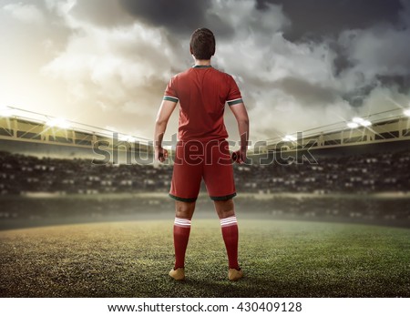 Asian football player standing on green grass stadium
