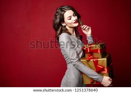 Beautiful sexy young brunette woman hair bright evening make-up red lips long fluffy eyelashes hold gift box holiday New Year  joy fun happy merry Christmas Eve party celebration St. Valentine\'s Day.