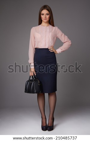 Beautiful sexy young business woman with evening make-up wearing a skirt to the knee and a silk blouse with lace long sleeves and high-heeled shoes business clothes for meetings and walks