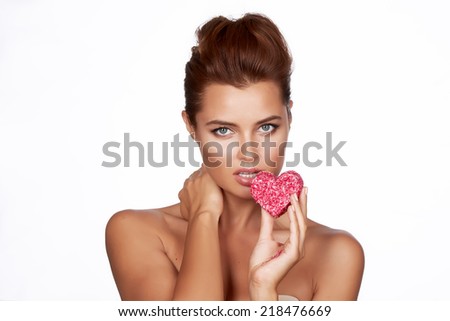 Beautiful sexy brunette woman eating cake shape of heart on a white background, healthy food, tasty, organic, romantic valentine day