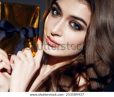 Beautiful young sexy brunette woman with bright evening make-up perfect smooth skin cosmetics cream face care, jewelry, beauty salon, magazine, close-up portrait with box present