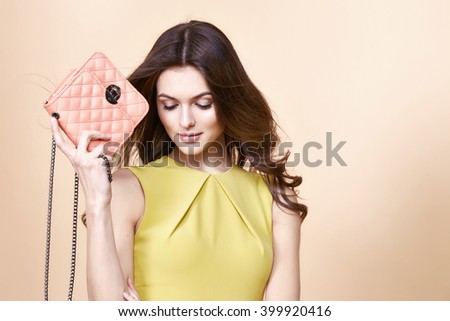 Glamour fashion woman long brunette curly hair natural evening makeup wear sexy short stylish yellow cotton dress from new catalog spring summer collection accessory handbag jewelry body shape care.