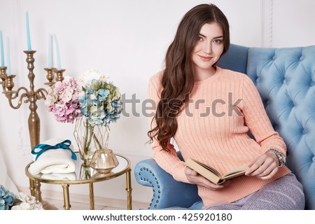 Beauty woman clever smart girl read book interview in perfect home interior comfort furniture wear casual fashion wool sweater style pants and clothes for office walk date natural makeup and sexy body