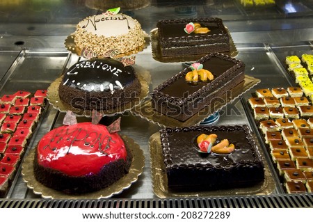 Window of a cake shop with a variety of cakes on display