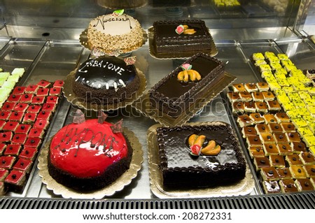 Window of a cake shop with a variety of cakes on display