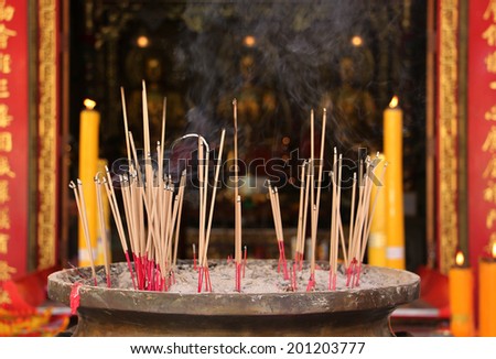 Joss Stick And Yellow Candle Burning At China Temple