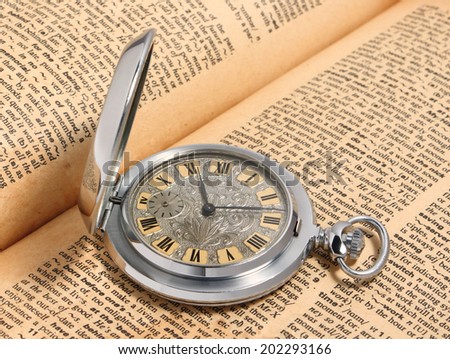 old pocket watch with old dictionary on \
