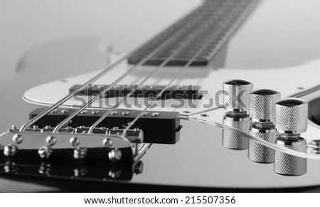 close up of electric bass guitar (focus at pickup and middle knobs of tone control)