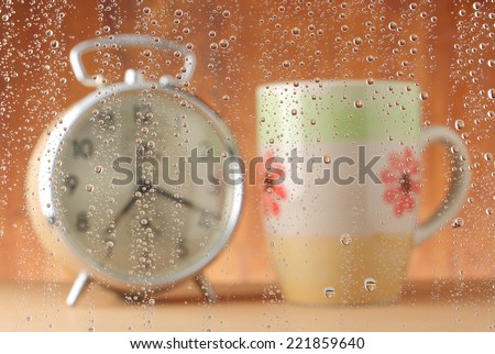 focus of water drops (alarm clock and coffee cup for background)