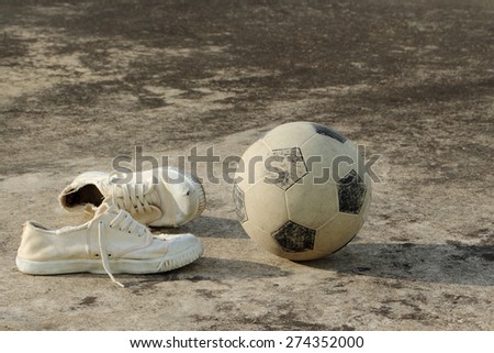 soccer ball with canvas shoes on concrete floor (street soccer background)