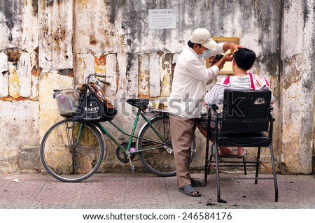 HO CHI MINH CITY, VIETNAM - JAN 20: An unknown man is having hair cut on January 20, 2013 in Ho Chi Minh City, Vietnam. This mobile or street barber shop is very convenient and suitable for the poor.