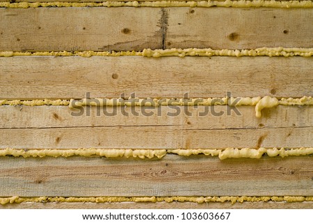 Close-up of Polyurethane foam filling gap in wooden construction, background