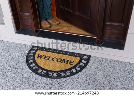 Welcome door mat with open door and a person