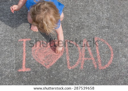 Baby Girl writing I Love Dad on Asphalt with Chalk, From Above