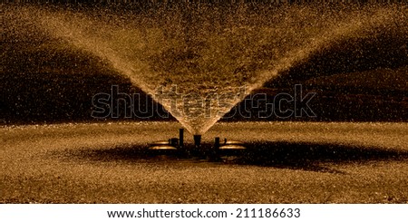 Water stream splashing on ground, Fountain,Water drops watering in arch curve shape. Closeup, shallow DOF