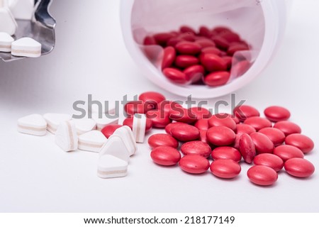 Red pills spilled around a pill bottle
