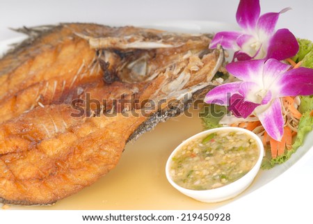 Deep Fried Tilapia fish fried with sauce spicy appetizing food on white plate in studio,Fish dish - deep fried fish with vegetables on white dish