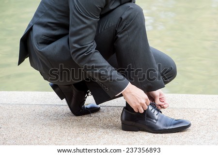 Lace shoes,A businessman is lacing his shoes,groom putting his wedding shoes. Hands of wedding groom getting ready in suit