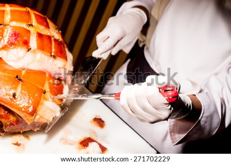 butcher\'s hand while fast cuts a piece of raw ham, cut ham