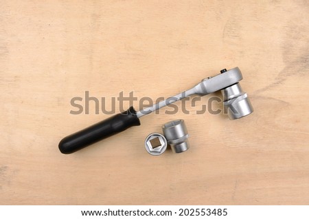 Socket wrench on wood background