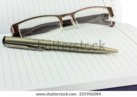 Notebook glasses and pen  isolated on white background.