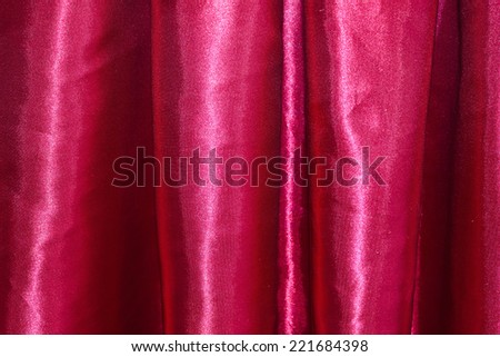 Red background, closeup of red silk textured cloth background.