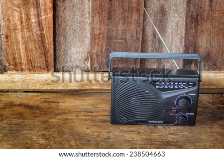 Vintage radio receiver device on wooden background.