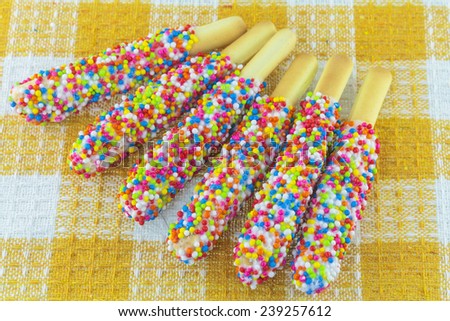 Closeup of many small decorative pieces of colorful sugar sweets on cookies