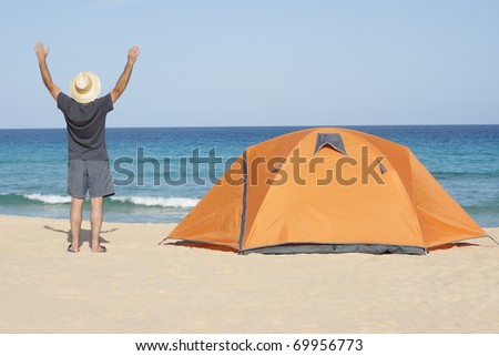 person with tent  enjoying camping recreation at a wonderful tranquil beach