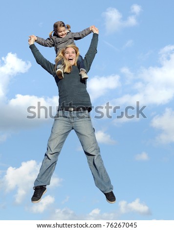 jumping happy mother and daughter enjoying a nice day together