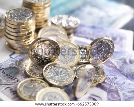 UK pound coins and notes used to illustrate consumer spending and saving.