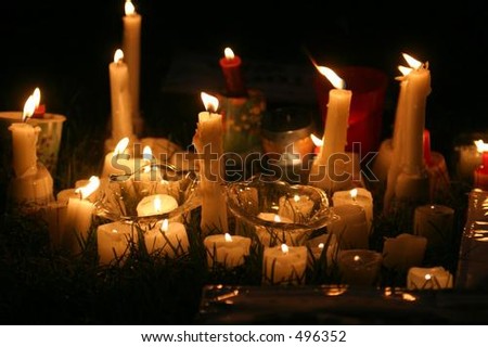 Candles in the grass at a park during a candle lit vigil.