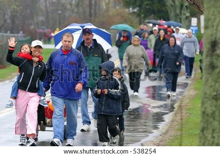 People walk in the rain for a fund-raising walkathon for multiple sclerosis. Editorial use only.
