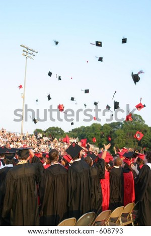 Tossing hats at a high school graduation. Vertical orientation. Editorial use only.