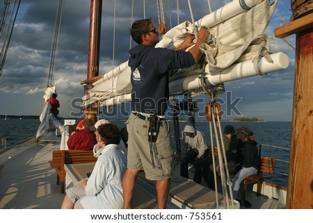 Crew and passengers on a sailing ship.Storm clouds in background. Editorial use only.