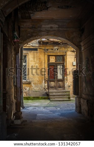 Old dark gateway in Odessa, Ukraine with a door and backyard