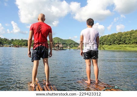 Two men stand in river  together.