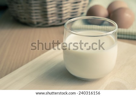 Close up glass of milk on wooden table with copy space,Vintage filter