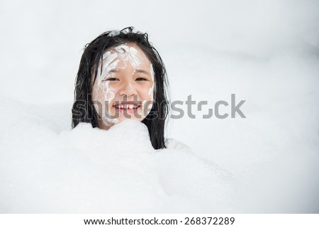 Little asian girl smiling in foam party on thai new year day