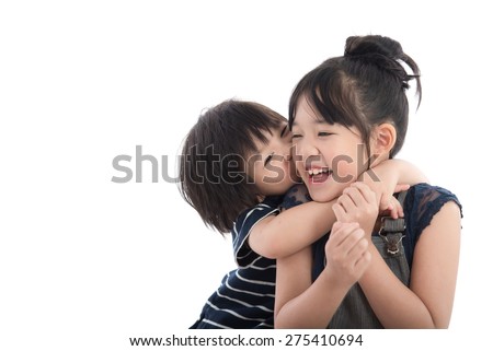 Little asian boy hugging and kissing his sister on white background isolated