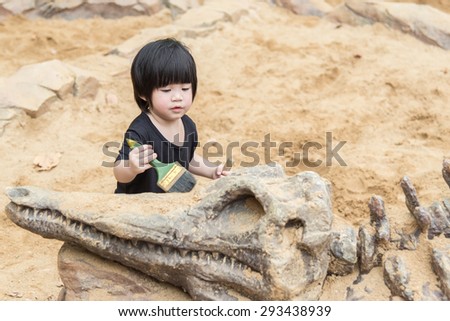 Little asian child have fun digging in the sand at adventure park