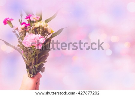 Carnation and flowers bouquet in hand holding with blur style sweet background bokeh