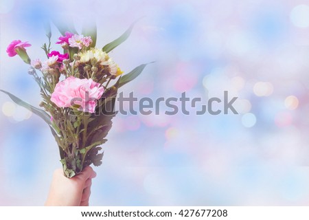 Carnation and flowers bouquet in hand holding with blur style sweet background bokeh