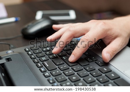 Hand of white man pressing Enter button on a laptop keyboard