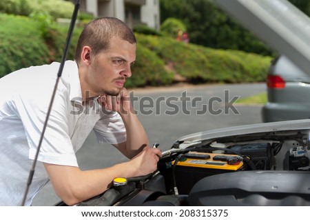 Young european man is thinking about what is wrong with his car