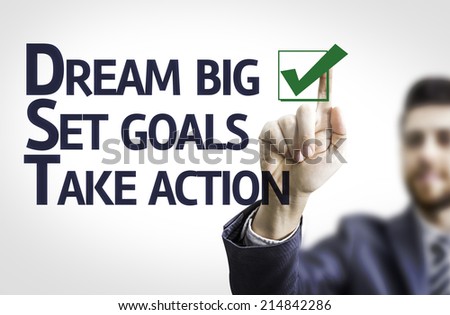 Business man pointing to transparent board with text: Dream Big / Seat Goals / Take Action