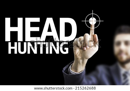 Business man pointing to black board with text: Head Hunting